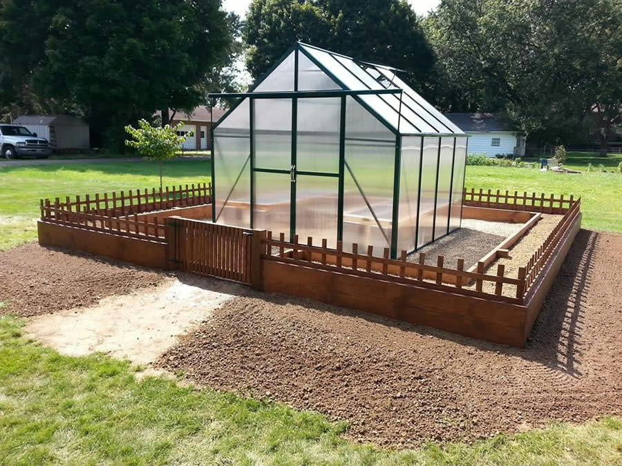 Greenhouse with wooden frame on a grassy area